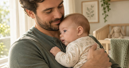 Father holding his 5-month-old baby at home with the baby's ear visible in profile